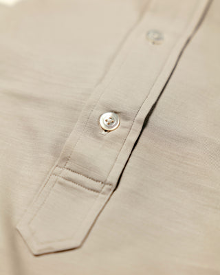 Close-up of a beige shirt with a button on a light background