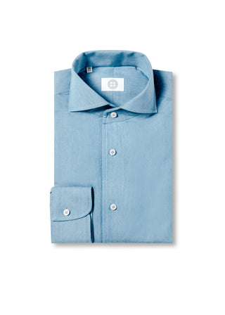 Folded light blue shirt with a brand label on a white background