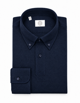 A folded dark navy blue long-sleeve button-down shirt with a classic collar and a single buttoned cuff, shown on a plain white background.
