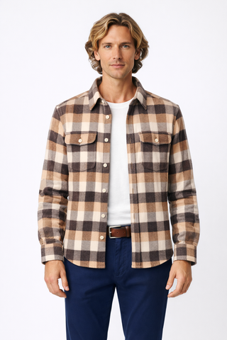 Man wearing a plaid shirt over a white t-shirt with blue pants on a white background