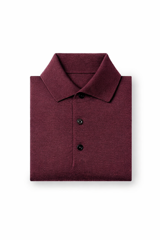Folded maroon polo shirt on a white background