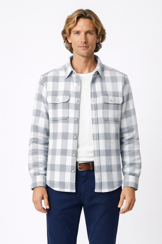 Man wearing a plaid shirt over a white t-shirt with blue pants on a white background